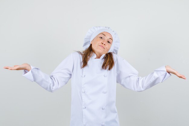 Köchin in weißer Uniform, die hilflose Geste zeigt und verwirrt aussieht
