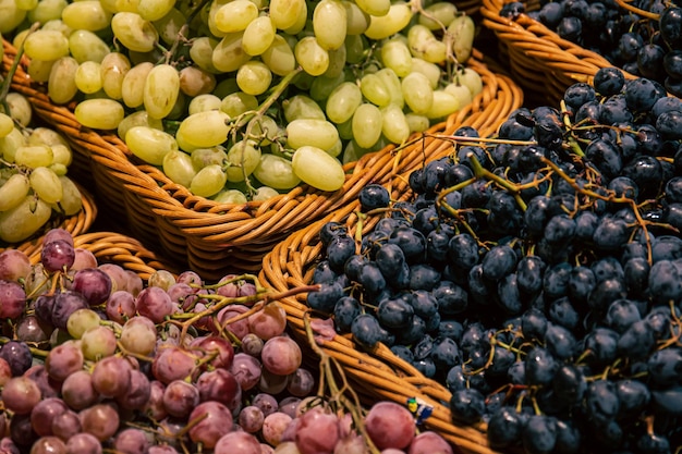 Körbe mit verschiedenen Traubensorten auf einer Supermarktvitrine