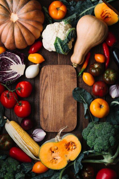 Köstliche Anordnung für Veggies der Draufsicht mit Schneidebrett