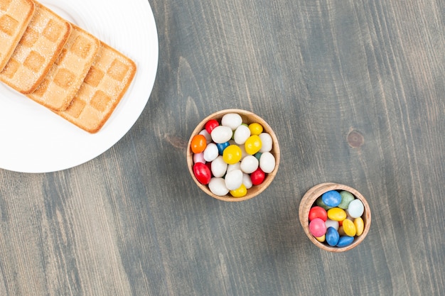 Köstliche bunte bonbons mit keksen auf einem weißen teller