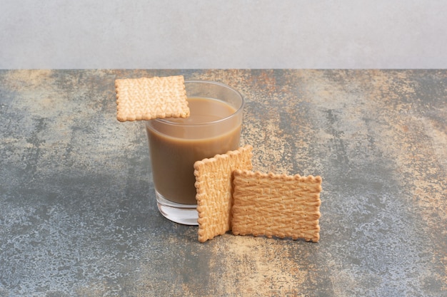 Köstliche Cracker mit Tasse Kaffee auf Marmorhintergrund. Hochwertiges Foto