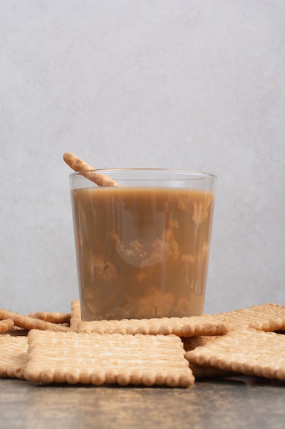 Köstliche Cracker mit Tasse Kaffee auf Marmorhintergrund. Hochwertiges Foto