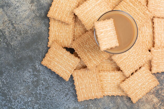 Kostenloses Foto köstliche cracker mit tasse kaffee auf marmorhintergrund. hochwertiges foto