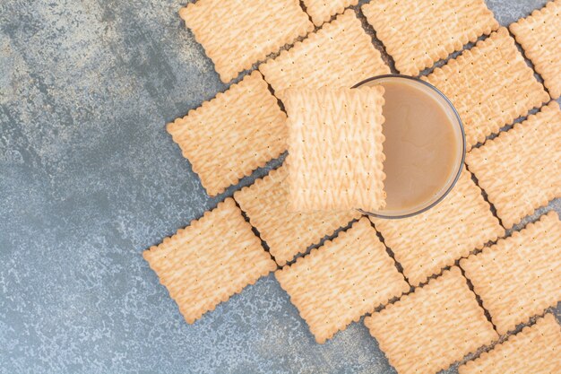 Köstliche Cracker mit Tasse Kaffee auf Marmorhintergrund. Hochwertiges Foto
