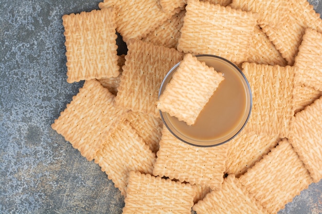 Köstliche Cracker mit Tasse Kaffee auf Marmorhintergrund. Hochwertiges Foto