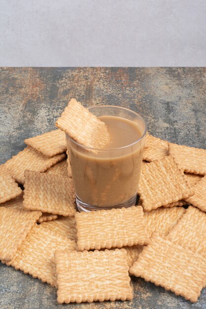 Köstliche Cracker mit Tasse Kaffee auf Marmorhintergrund. Hochwertiges Foto