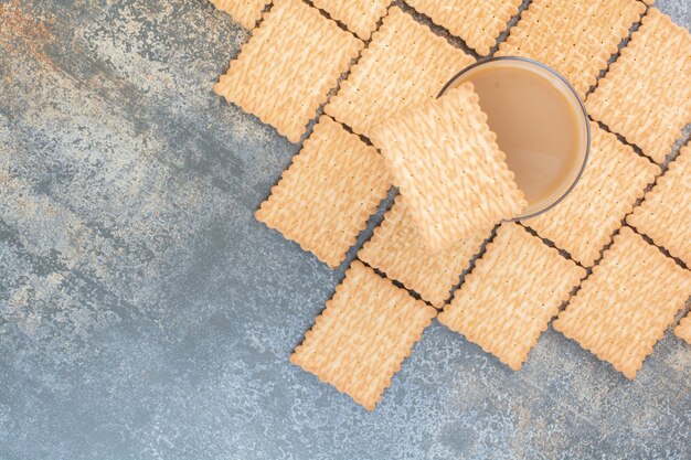 Köstliche Cracker mit Tasse Kaffee auf Marmorhintergrund. Hochwertiges Foto