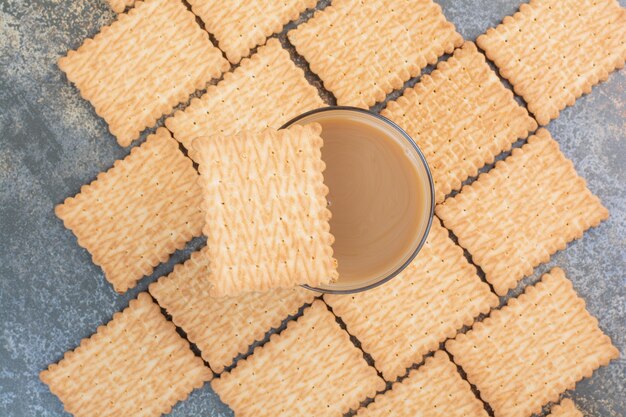 Köstliche Cracker mit Tasse Kaffee auf Marmorhintergrund. Hochwertiges Foto