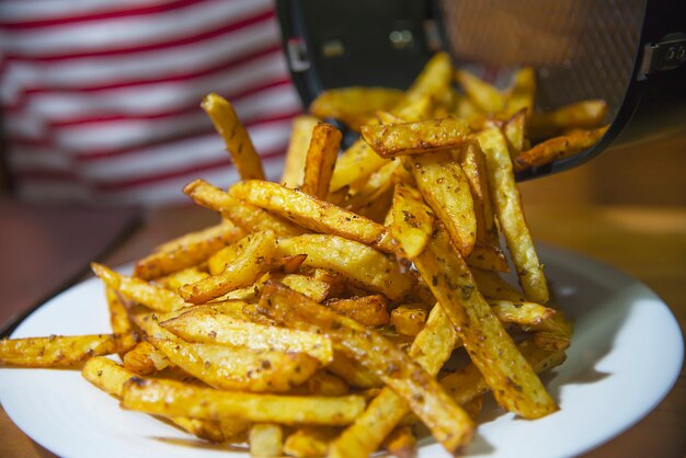 Köstliche französische gebratene Kartoffelmischung mit kaltem Pulver auf Holztisch