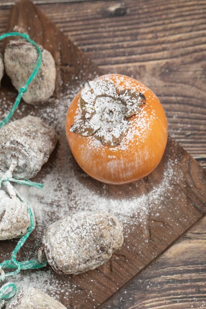 Köstliche frische und getrocknete Kakifrüchte auf Holzbrett