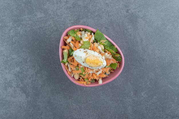 Köstliche gekochte Eier und frischer Salat in rosa Schüssel.