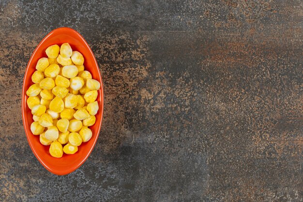 Köstliche gelbe Bonbons in der orangefarbenen Schüssel.