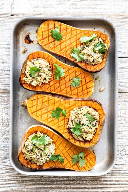 Köstliche geröstete Butternut-Kürbis-Curry-Reisschüssel auf Holztisch wooden