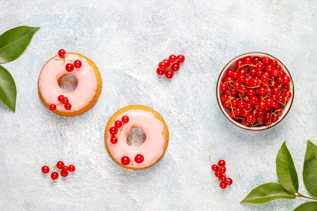 Köstliche hausgemachte Glasur Donuts mit roten Johannisbeeren.