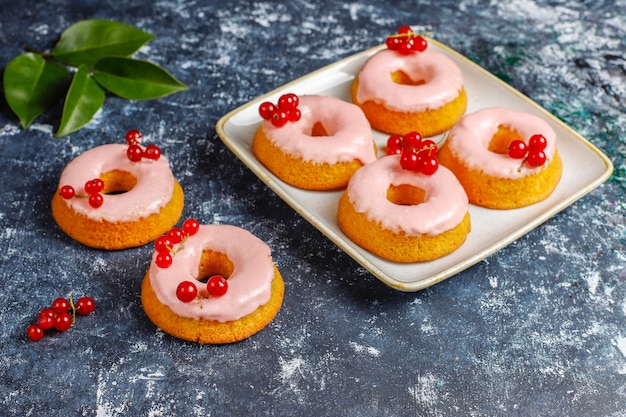 Köstliche hausgemachte Glasur Donuts mit roten Johannisbeeren.