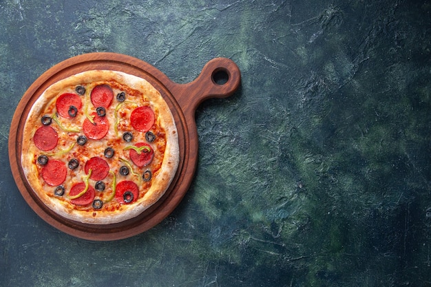 Köstliche hausgemachte Pizza auf Holzbrett auf der rechten Seite auf isolierter dunkler Oberfläche
