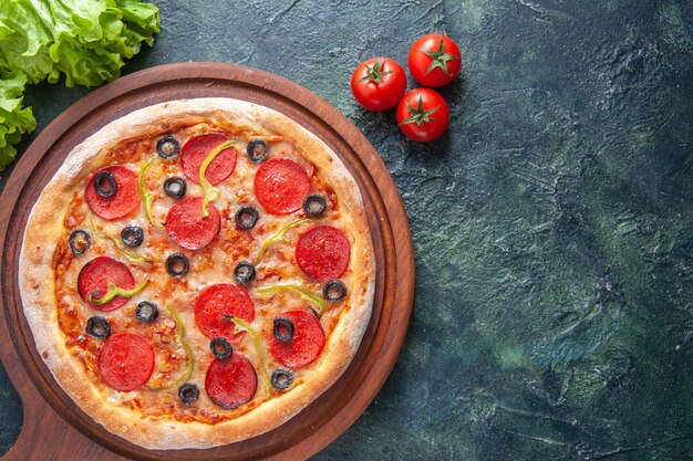 Köstliche hausgemachte Pizza auf Holzbrett Tomaten Ketchup grünes Bündel auf dunkler Oberfläche