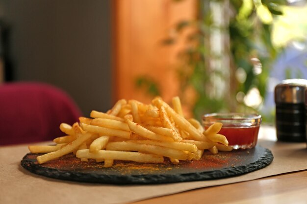 Köstliche heiße Pommes Frites mit roter Soße auf dem Tisch serviert