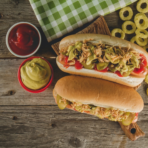 Köstliche Hot Dogs mit Saucen und Zwiebelringen