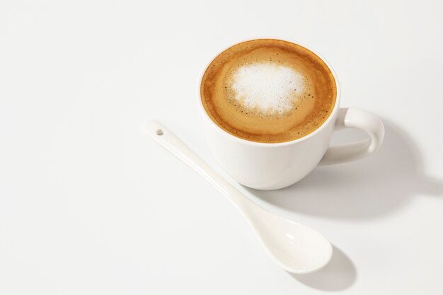 Köstliche Kaffeetasse und Löffel des hohen Winkels