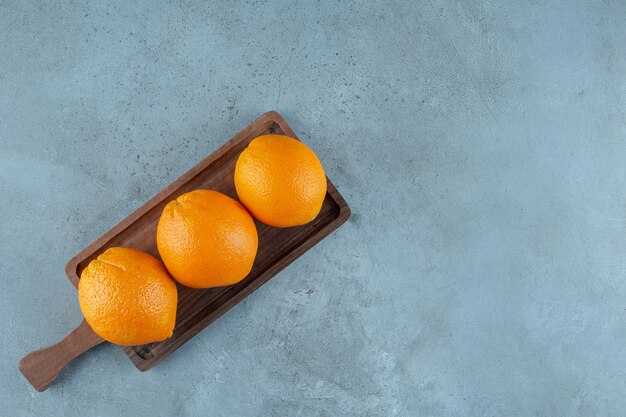 Köstliche Orangen auf einem Brett, auf dem Marmorhintergrund. Foto in hoher Qualität