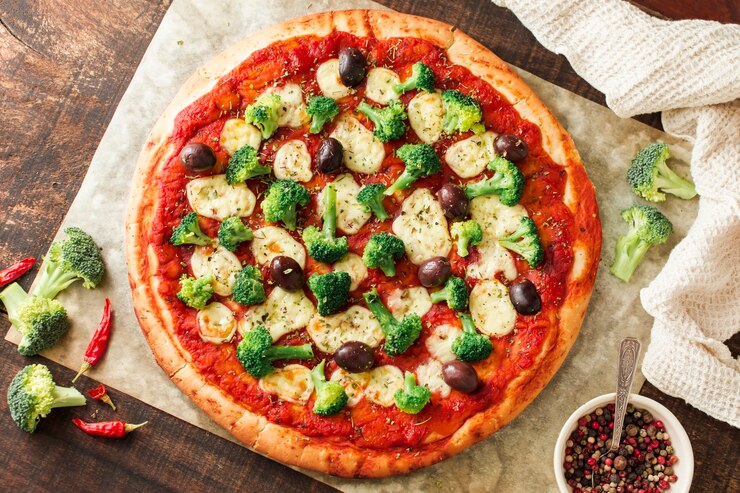Kostenlose Foto köstliche pizza auf holztisch mit bestandteilen