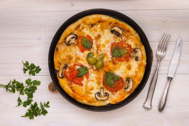 Köstliche Pizza mit Tomaten und frischem Pilz und Oliven auf hölzernem Hintergrund