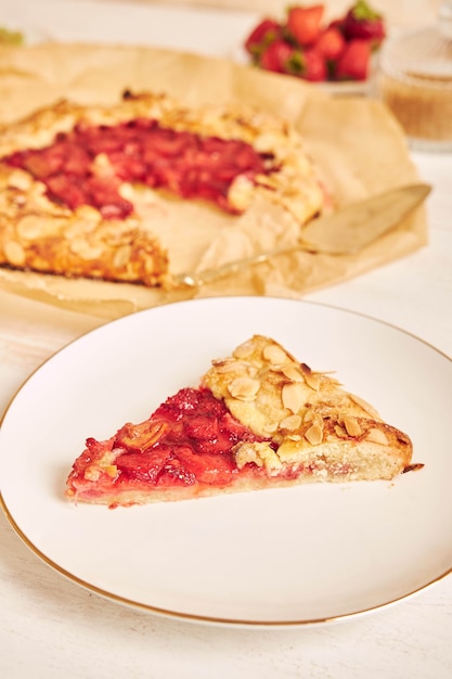 Köstliche Rhabarber-Erdbeer-Gallate-Kuchen mit Zutaten auf einem weißen Tisch