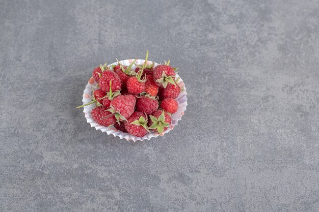 Köstliche rote Himbeeren in buntem Papier. Foto in hoher Qualität