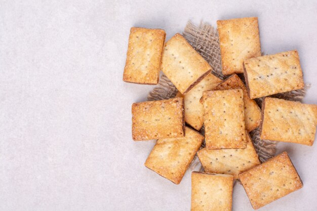 Köstliche süße Cracker auf Sackleinen auf weißem Hintergrund. Hochwertiges Foto