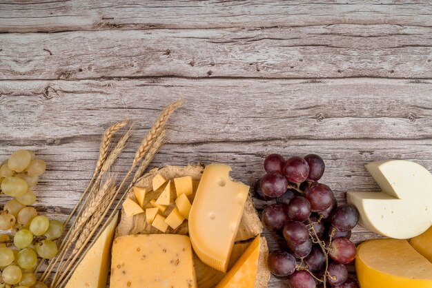 Köstliche Vielzahl der Draufsicht des Käses mit Trauben auf dem Tisch