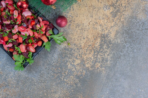 Köstliche Vinaigrette mit Weihnachtskugeln auf einem dunklen Hintergrund. Hochwertiges Foto