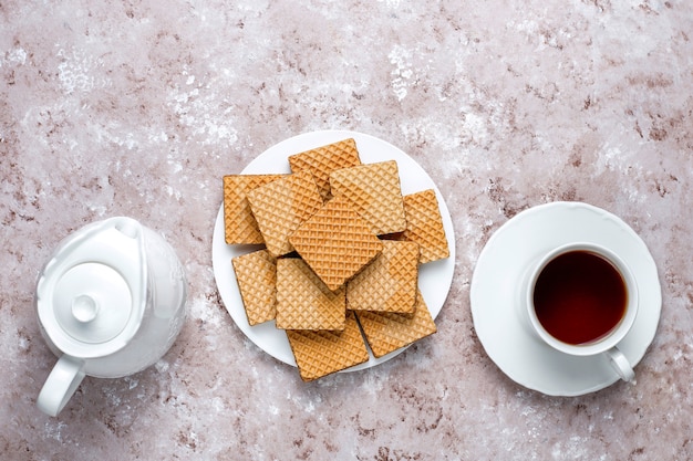 Köstliche Waffeln und eine Tasse Kaffee zum Frühstück auf hellem Hintergrund, Draufsicht