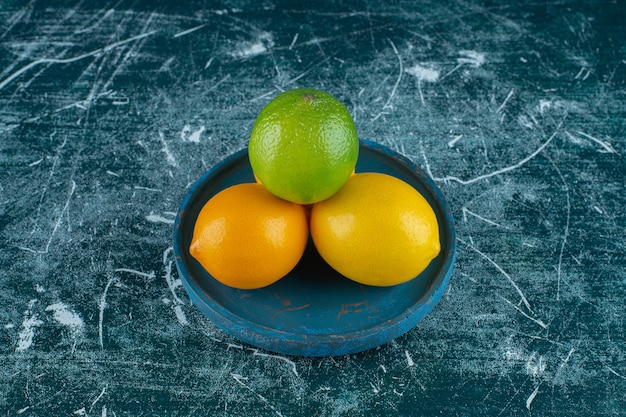 Köstliche Zitronen auf einer Holzplatte, auf dem Marmorhintergrund. Foto in hoher Qualität