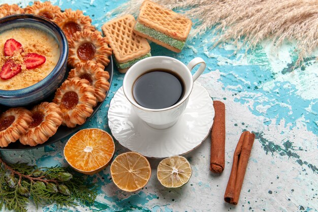 Köstliche Zuckerkekse mit halber Draufsicht mit Waffeltasse Kaffee und Erdbeerdessert auf der blauen Oberfläche-Kekskeks-Süßkuchen-Dessertfarbe