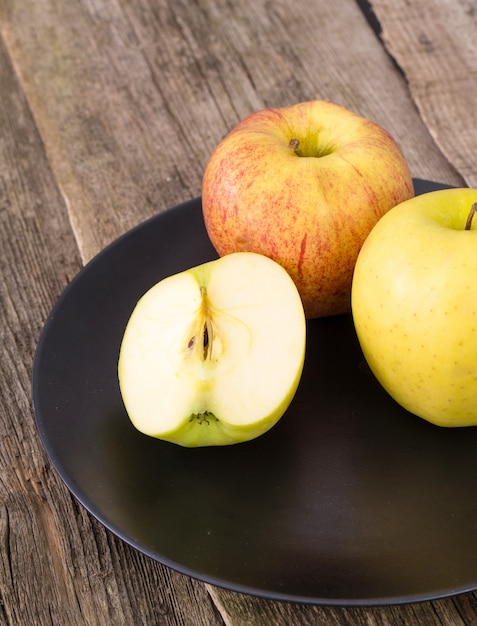 köstlicher Apfel auf einem Teller über einem Holztisch