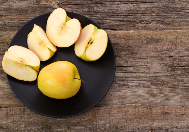 Kostenloses Foto köstlicher apfel auf einem teller über einem holztisch