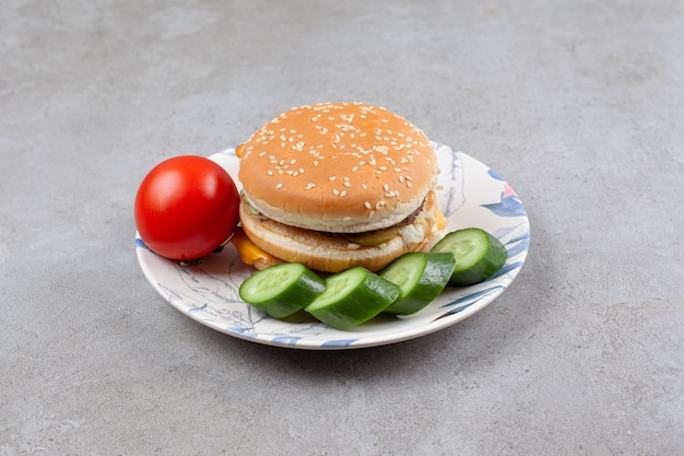 Köstlicher Burger mit Gemüse auf buntem Teller