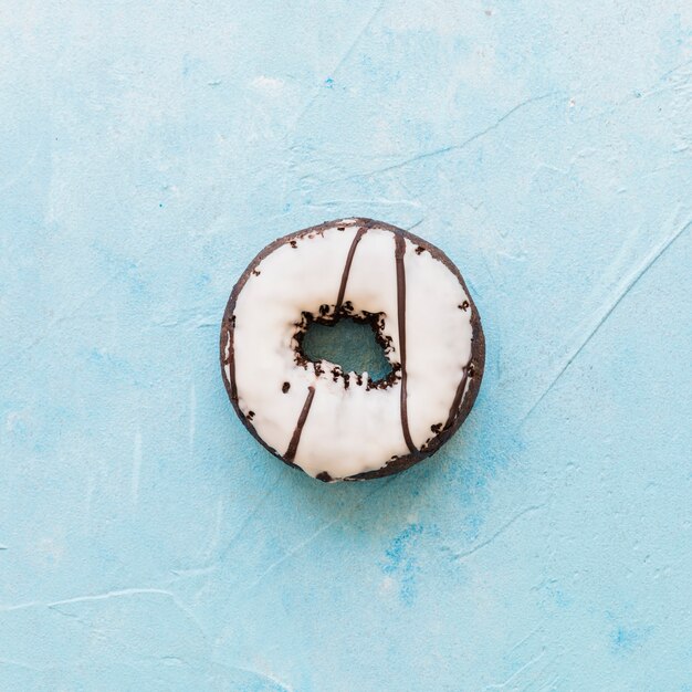 Köstlicher Donut mit Zuckerglasur auf blauem Hintergrund
