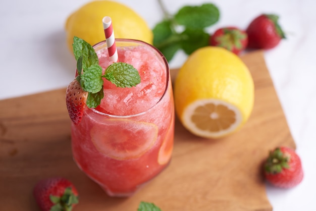 Köstlicher Erdbeer-Zitronen-Smoothie garniert mit frischer Erdbeere und Minze im Glas. Weicher Fokus. schöne Vorspeise rosa Erdbeere, Wohlbefinden und Gewichtsverlustkonzept.