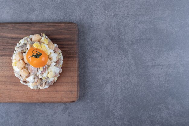 Köstlicher Fleischsalat auf Holzbrett.