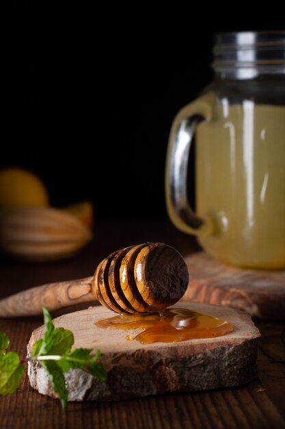 Köstlicher Honigstock der Nahaufnahme und Limonadenglas