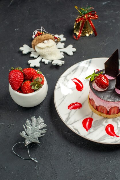 Köstlicher Käsekuchen der Vorderansicht mit Erdbeere und Schokolade auf ovaler Tellerschüssel mit Erdbeeren