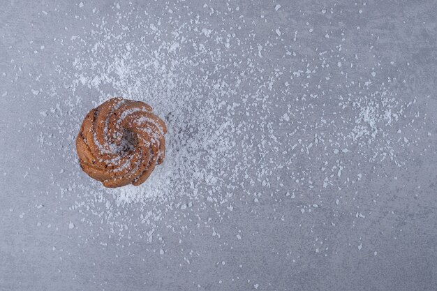 Köstlicher Keks auf einem Haufen Vanillepulver auf Marmoroberfläche