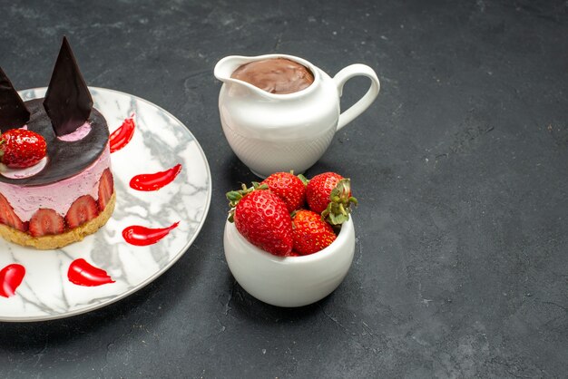 Köstlicher Kuchen der Vorderansicht mit Erdbeere und Schokolade auf ovaler Tellerschüssel mit Erdbeeren