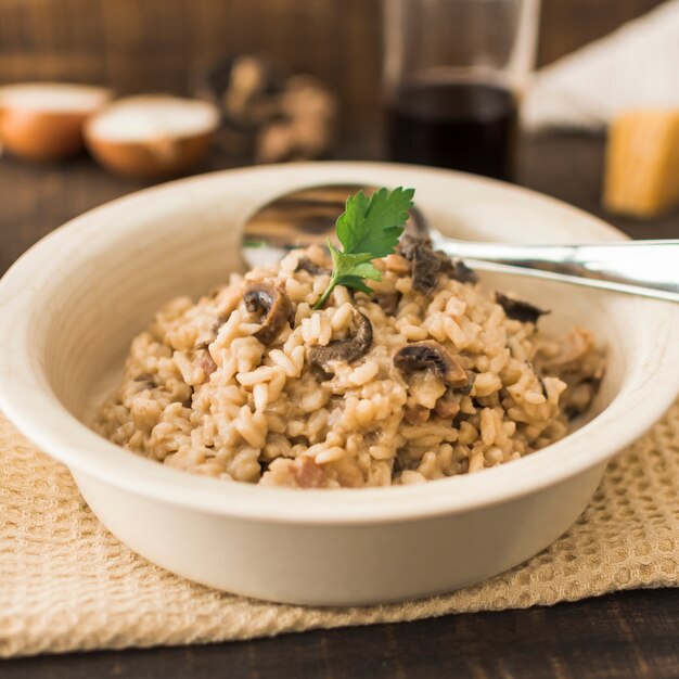 Köstlicher Pilz Risotto in der weißen Schüssel mit Löffel