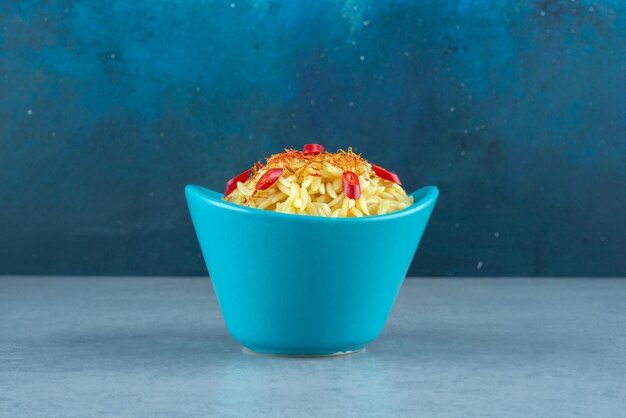 Köstlicher Reis mit Tomatenscheiben in blauer Schüssel.