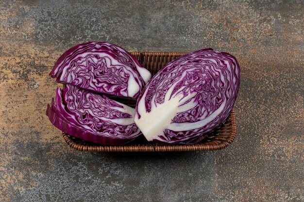 Köstlicher Rotkohl im Weidenkorb auf der Marmoroberfläche