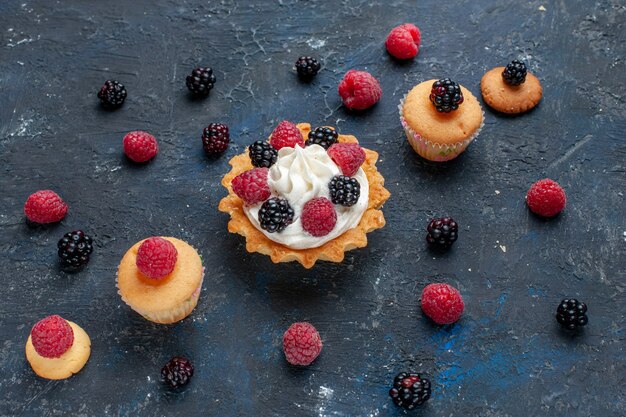 köstlicher süßer Kuchen mit verschiedenen Beeren und leckerer Sahne auf dunkelgrauem Obstkuchen mit Fruchtbeerenkuchen