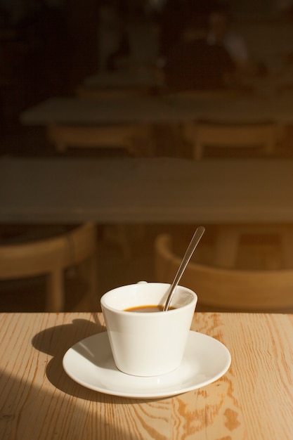 Köstlicher Tasse Kaffee mit Untertasse auf Tabelle im cafÃ ©